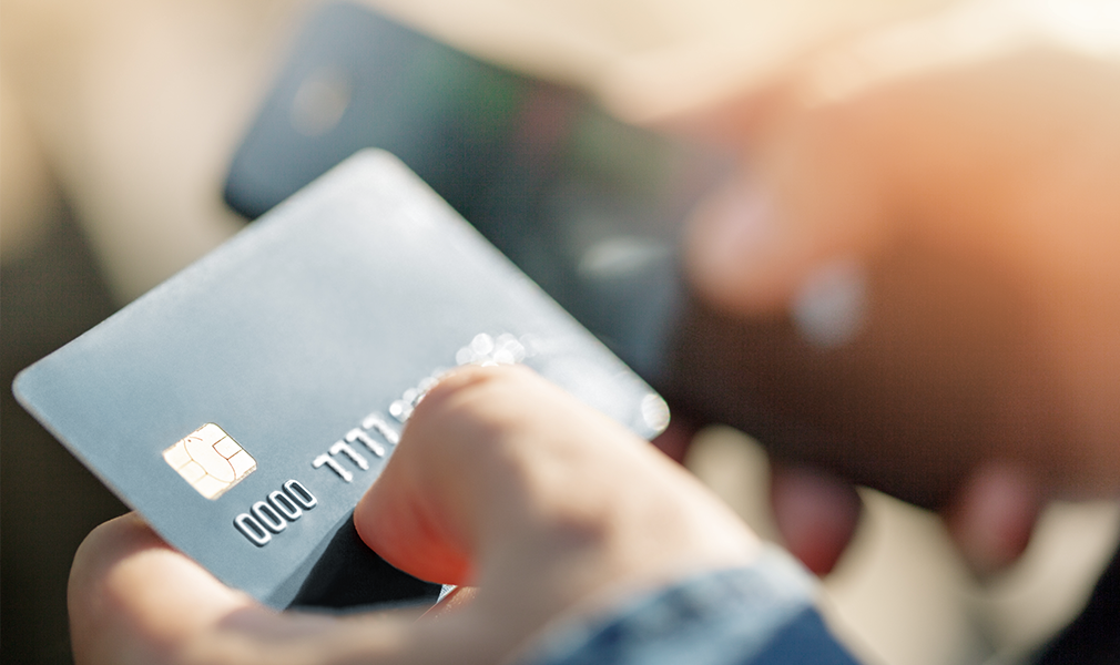 A person holds a credit card in their left hand.