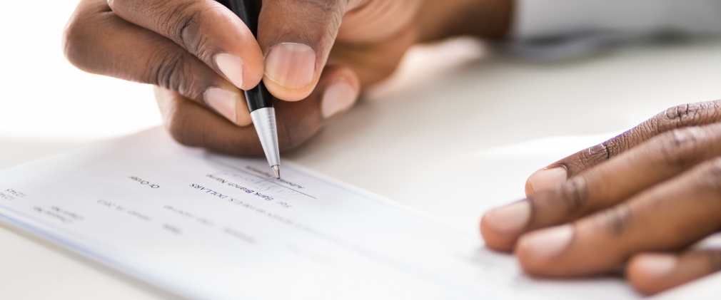 Close up of a person writing a check