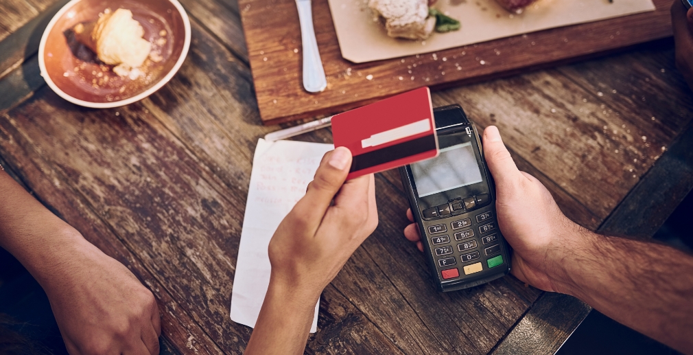 Close up of a person paying for a meal with a credit card