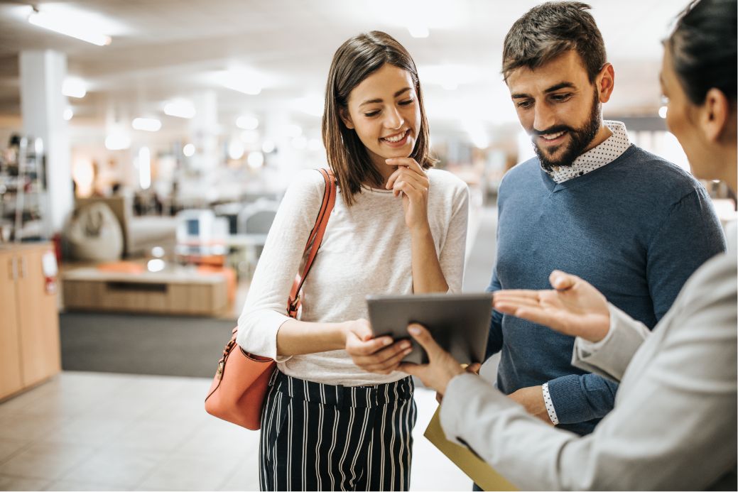 Three people looking at an tablet together.