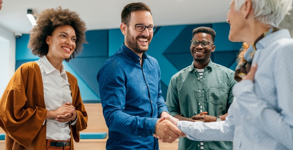Group of employees enthusiastically welcome a new hire