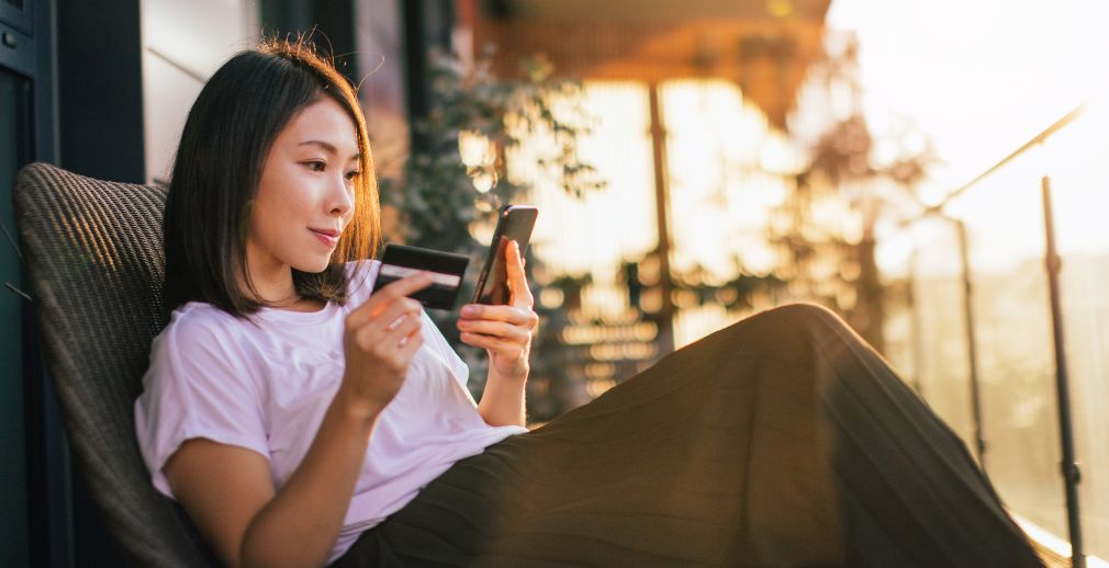A woman entering her credit card information to make a mobile payment on her phone