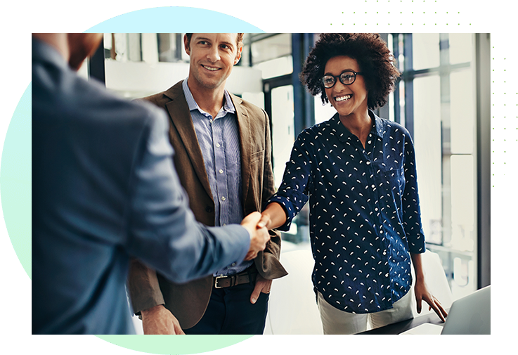 Woman shaking hands with man in office building lobby