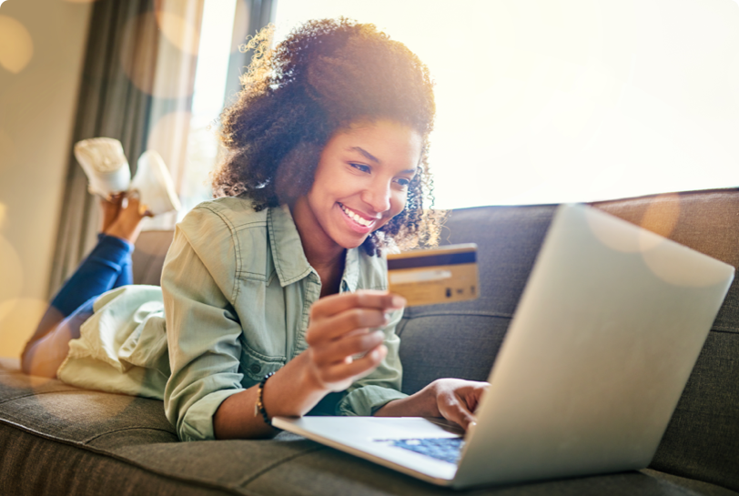 woman holding her credit card making a payment on her laptop