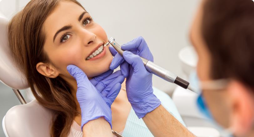 dentist cleaning womans teeth