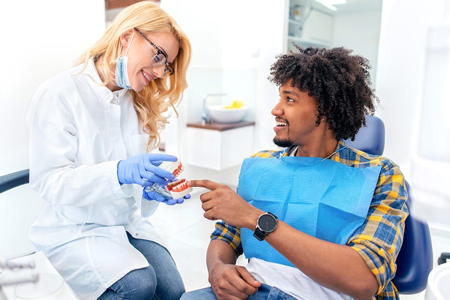 A dentist speaking with a patient in the office.