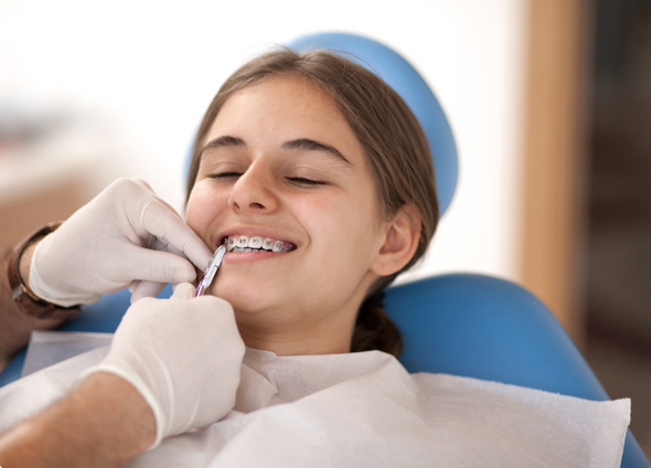 girl patient at the orthodontist having braces checked
