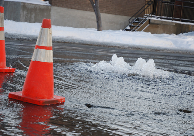 cones in a roadway with rushing water