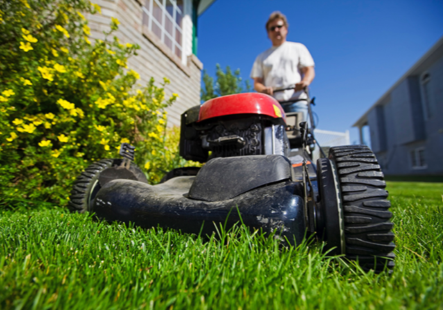 man cutting his grass with a lawn mower 