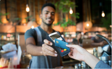 women making NFC payment with her credit card at store
